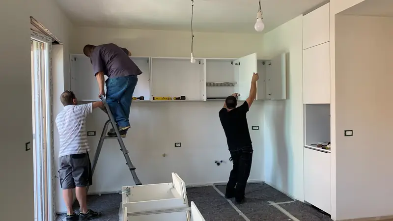 Artisans posant les meubles d'une cuisine