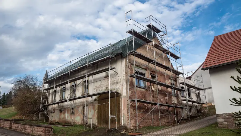 Maison ancienne sous échafaudage pendant sa rénovation